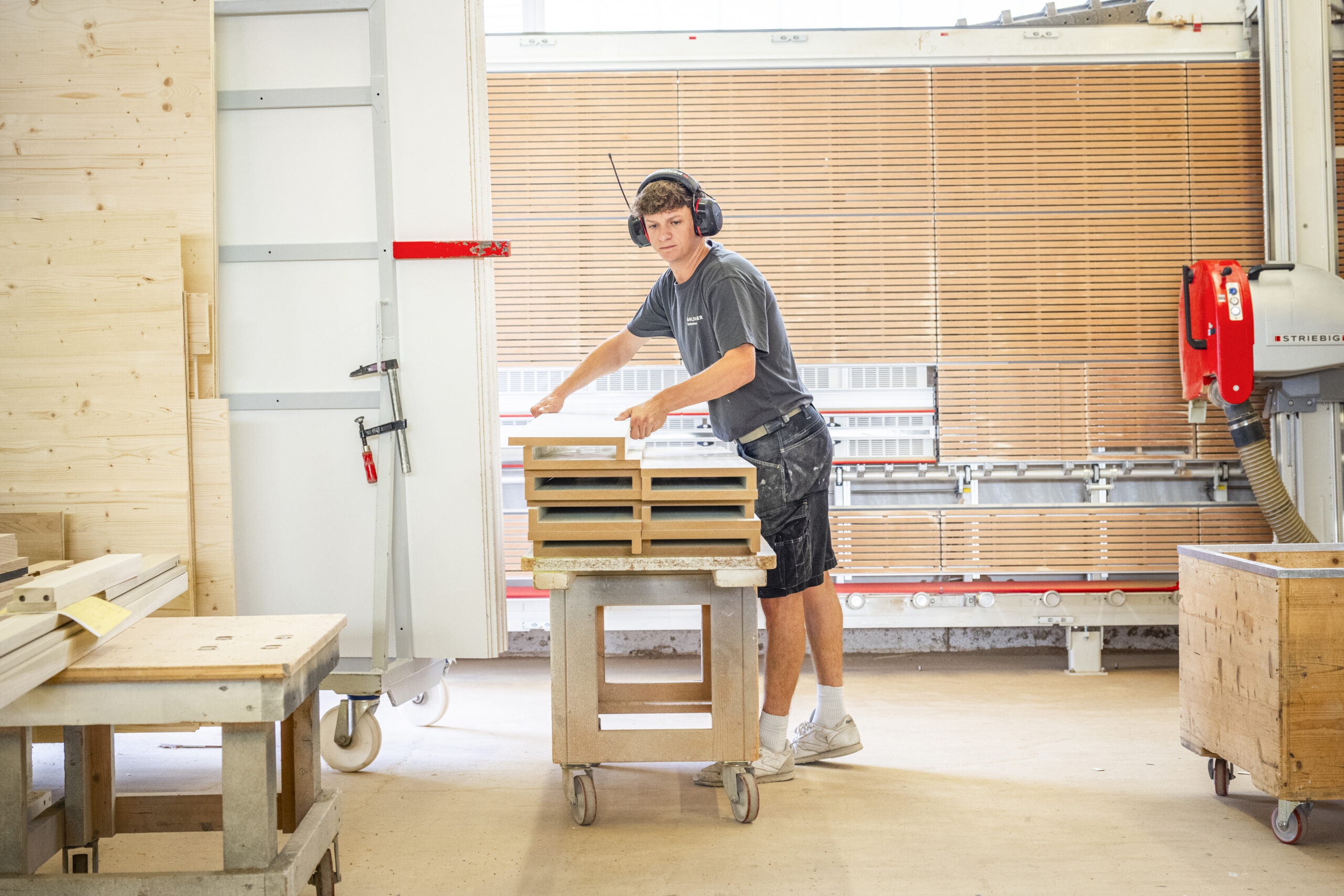 Mitarbeitende der Schreinerei Goldinger beim Transport und der Vorbereitung von Holzbauteilen.