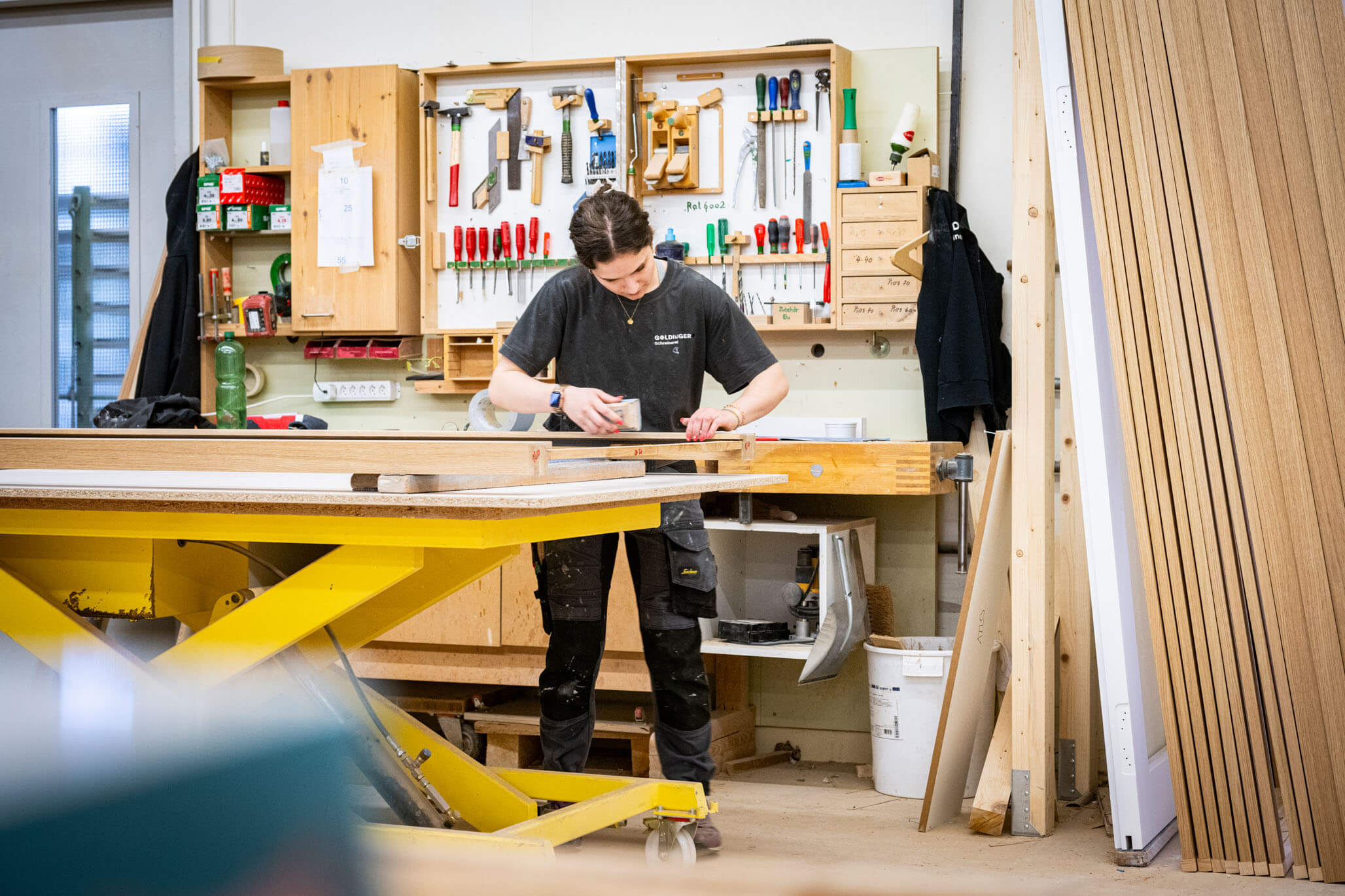 Mitarbeitende der Schreinerei Goldinger bei der Bearbeitung eines Werkstücks in der Werkstatt.